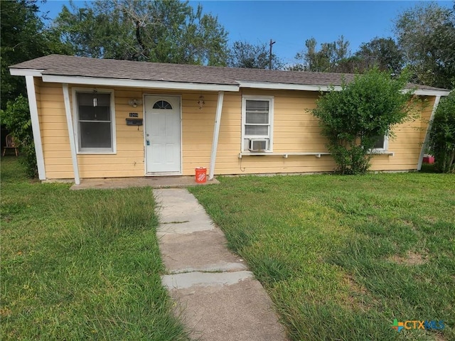bungalow-style home with a front lawn and cooling unit