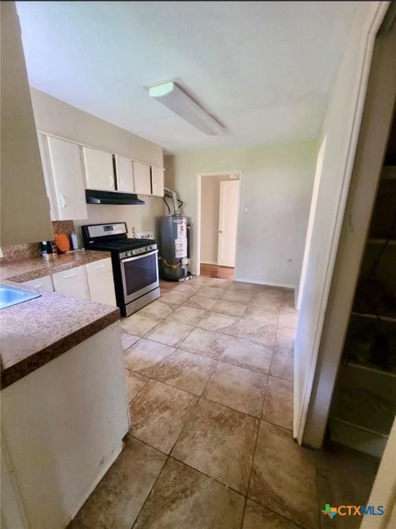 kitchen with stainless steel range with gas cooktop, white cabinetry, under cabinet range hood, a sink, and water heater