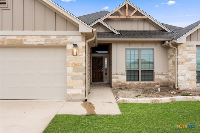 view of front of property featuring a garage, stone siding, board and batten siding, and roof with shingles