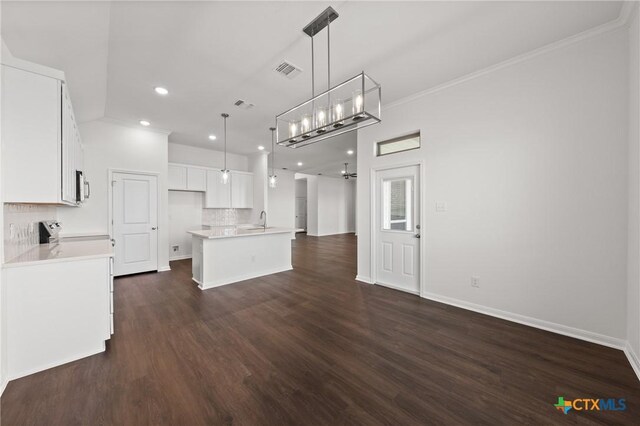 kitchen with dark wood finished floors, tasteful backsplash, stove, white cabinetry, and a sink