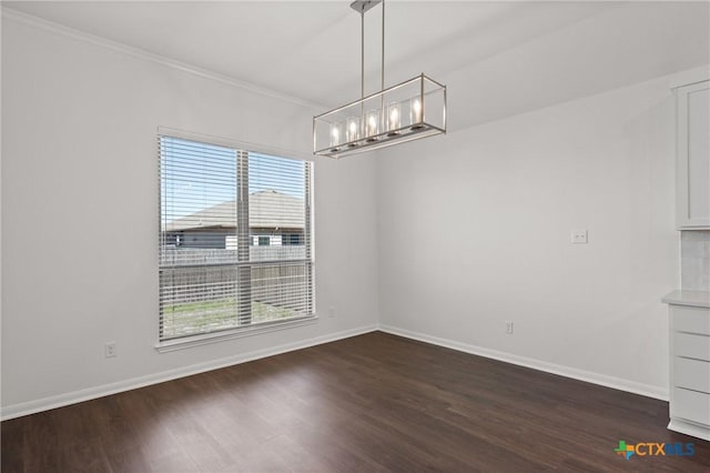 unfurnished dining area with dark wood-type flooring, a notable chandelier, ornamental molding, and baseboards