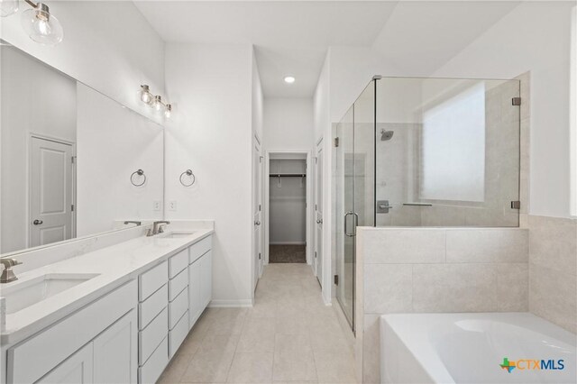 bathroom with a garden tub, double vanity, a sink, and a shower stall