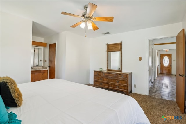 bedroom featuring carpet floors, ensuite bathroom, and ceiling fan