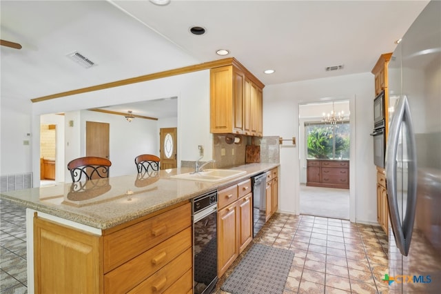 kitchen featuring a breakfast bar area, kitchen peninsula, tasteful backsplash, and black appliances