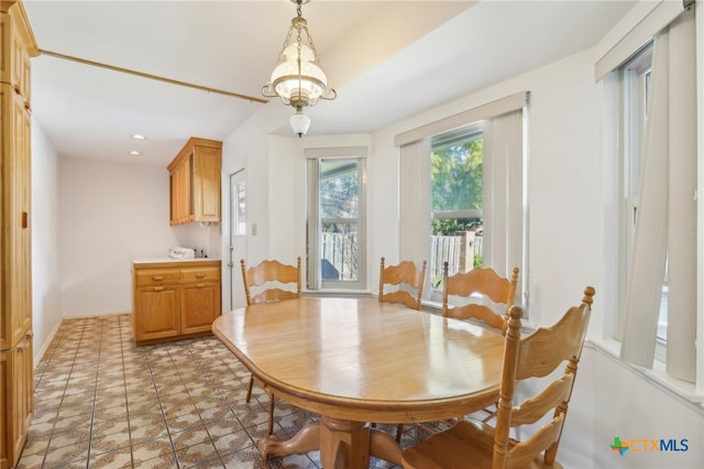 tiled dining area featuring a chandelier