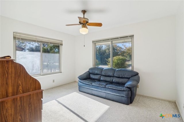 carpeted living room with ceiling fan