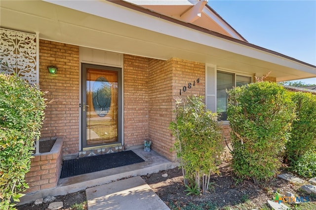 view of exterior entry featuring covered porch