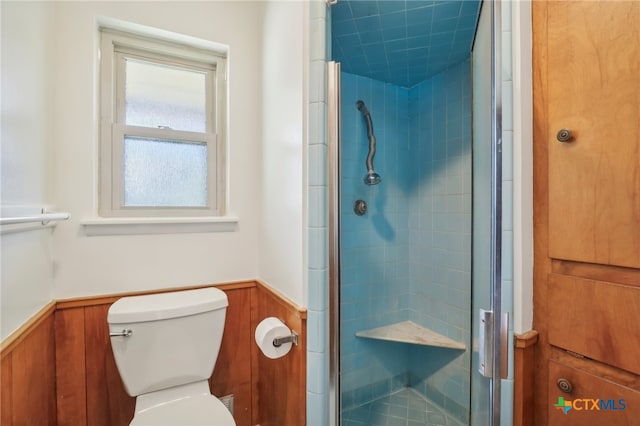 bathroom with toilet, a shower with door, and wooden walls