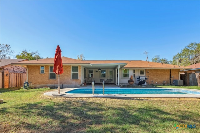 back of house with ceiling fan, a yard, and central AC