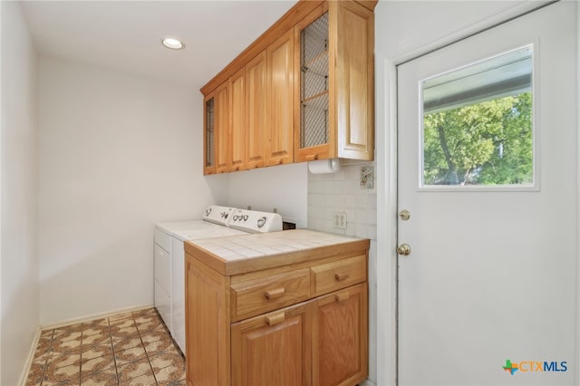 laundry area with tile patterned floors, cabinets, and washer / dryer