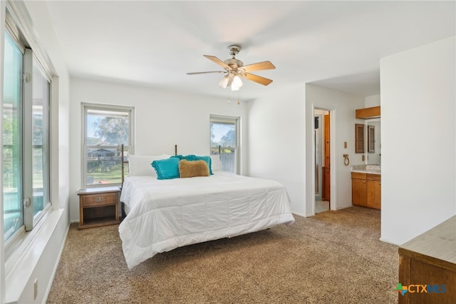 bedroom with ensuite bathroom, ceiling fan, and light carpet