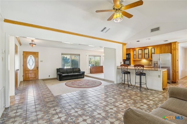 living room with light tile patterned floors, vaulted ceiling, ceiling fan, and ornamental molding