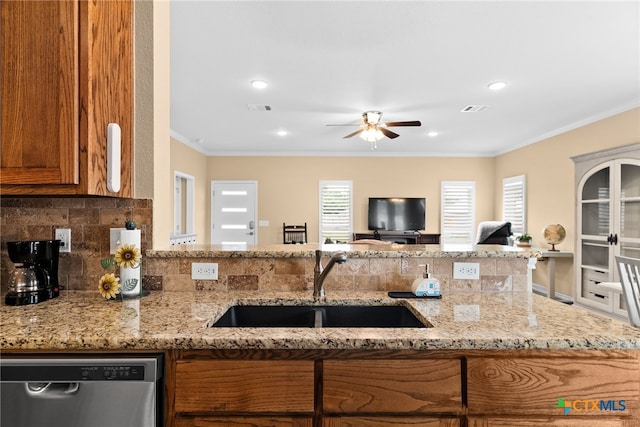 kitchen featuring stainless steel dishwasher, light stone countertops, sink, and ornamental molding