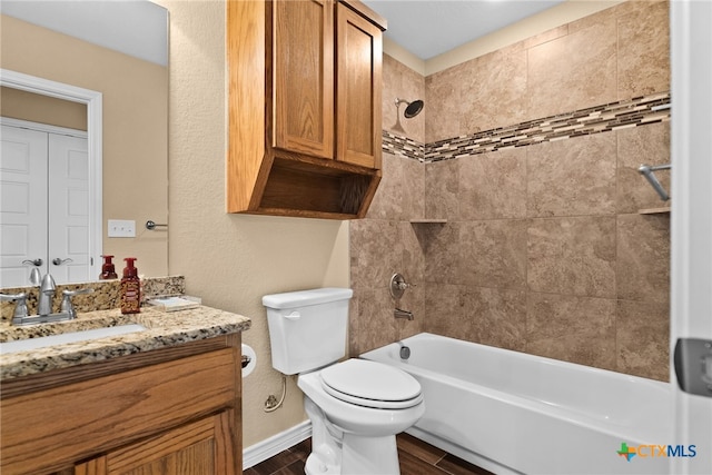 full bathroom featuring hardwood / wood-style flooring, vanity, toilet, and tiled shower / bath combo