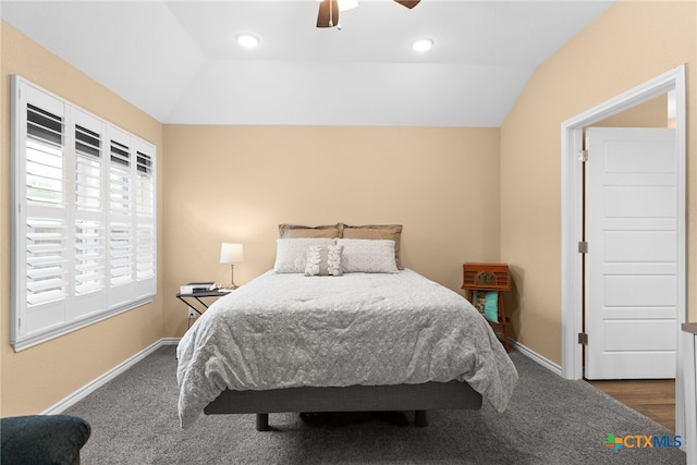 bedroom featuring ceiling fan, vaulted ceiling, and dark carpet