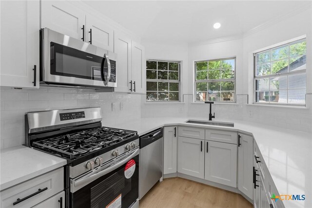 1701 Southwestern Trl, Round Rock, TX 78664 - kitchen featuring stainless steel appliances, a sink, tasteful backsplash, light countertops, and white cabinetry