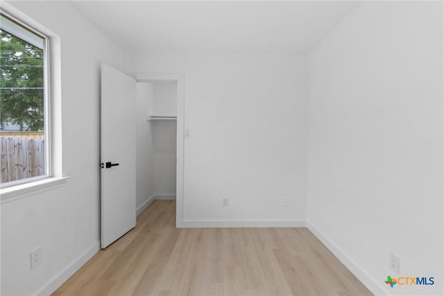 1701 Southwestern Trl, Round Rock, TX 78664 - unfurnished bedroom featuring wood finished floors, a walk in closet, and baseboards