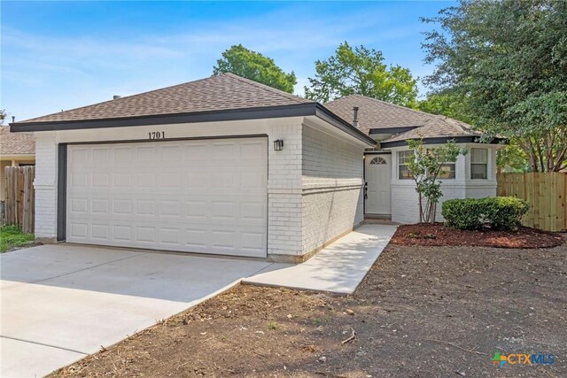 1701 Southwestern Trl, Round Rock, TX 78664 - single story home with brick siding, a garage, a shingled roof, and concrete driveway