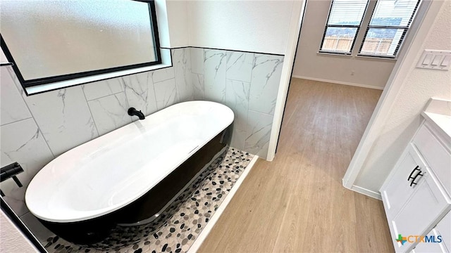 1486 Walker Place Blvd, Copperas Cove, TX 76522 - full bath with a textured wall, wood finished floors, a freestanding tub, and tile walls