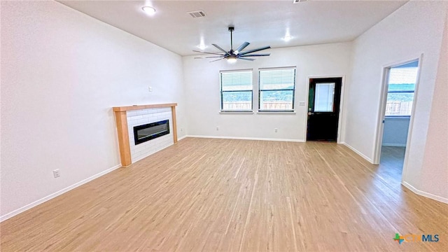 1486 Walker Place Blvd, Copperas Cove, TX 76522 - unfurnished living room featuring ceiling fan, light wood-style flooring, visible vents, baseboards, and a glass covered fireplace