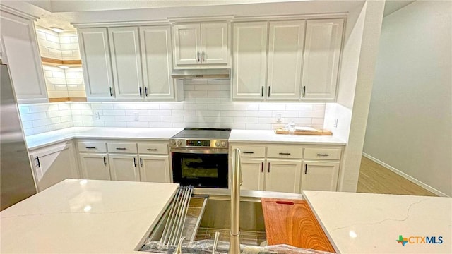 1486 Walker Place Blvd, Copperas Cove, TX 76522 - kitchen featuring light wood finished floors, stainless steel appliances, decorative backsplash, under cabinet range hood, and baseboards
