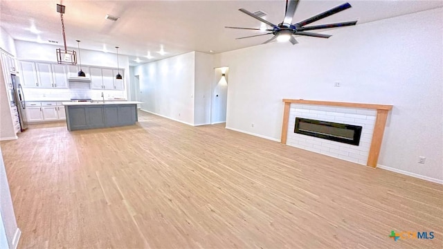 1486 Walker Place Blvd, Copperas Cove, TX 76522 - kitchen featuring light wood-style flooring, a fireplace, white cabinets, open floor plan, and freestanding refrigerator