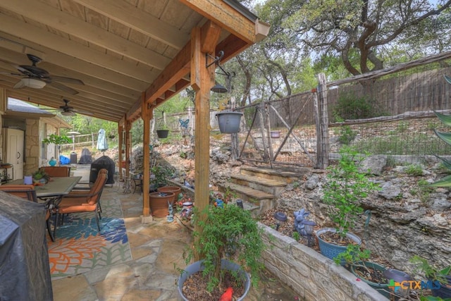 view of patio with outdoor dining space, ceiling fan, and fence