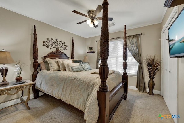 bedroom featuring visible vents, baseboards, ceiling fan, crown molding, and light carpet