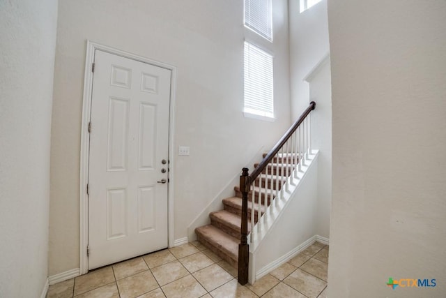 2241 Windswept Way, New Braunfels, TX 78132 - foyer entrance with stairs, light tile patterned floors, baseboards, and a towering ceiling