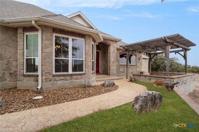 doorway to property with stone siding, roof with shingles, and a pergola