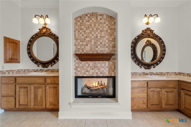 bathroom with a sink, crown molding, and tile patterned floors