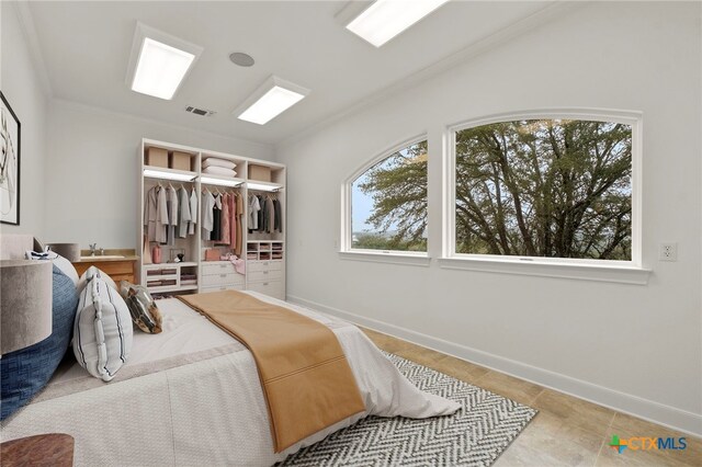 tiled bedroom featuring a closet, visible vents, baseboards, and crown molding