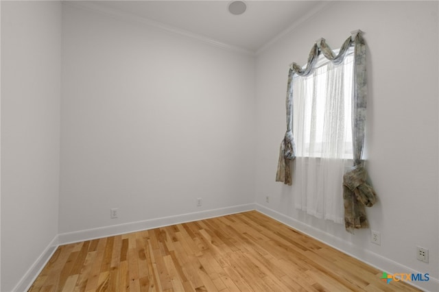 unfurnished room with ornamental molding, baseboards, and light wood-style flooring