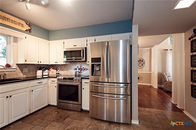 3501 Grizzly Bear Trl, Temple, TX 76502 - kitchen with stainless steel appliances, a sink, stone tile flooring, dark countertops, and decorative backsplash