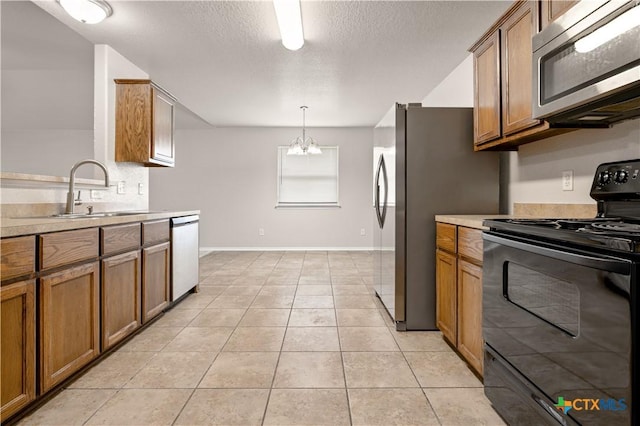 503 Chrislyn St, Troy, TX 76579 - kitchen featuring appliances with stainless steel finishes, brown cabinetry, light countertops, a textured ceiling, and light tile patterned flooring