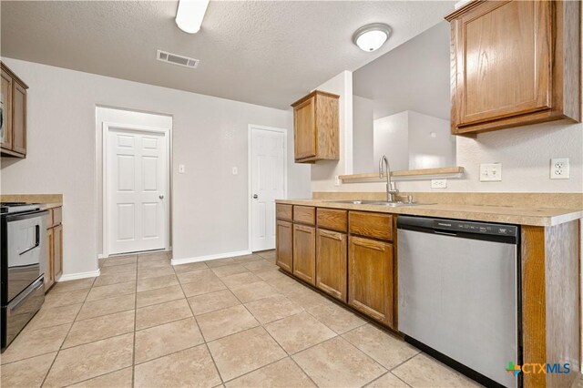 503 Chrislyn St, Troy, TX 76579 - kitchen featuring stainless steel appliances, light countertops, light tile patterned flooring, a textured ceiling, and brown cabinets