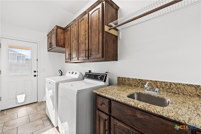 laundry room featuring cabinets, washing machine and dryer, light tile patterned floors, and sink