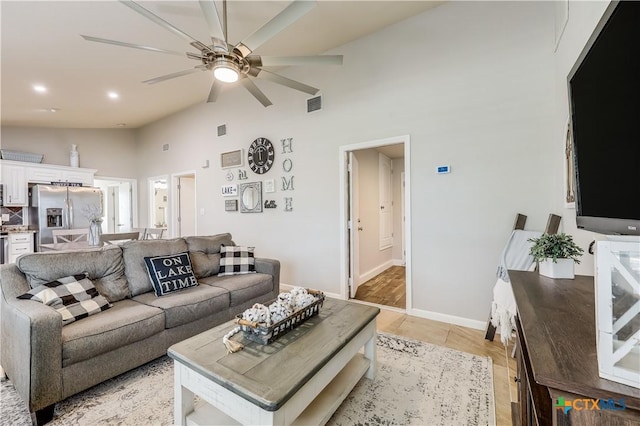 tiled living room with high vaulted ceiling and ceiling fan