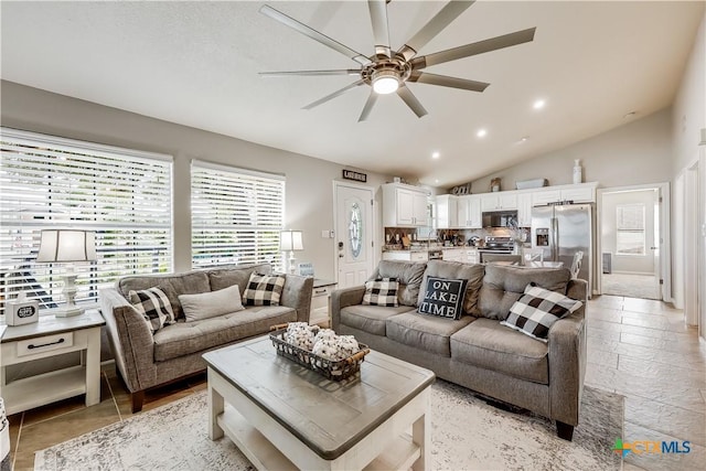 living room featuring ceiling fan and lofted ceiling