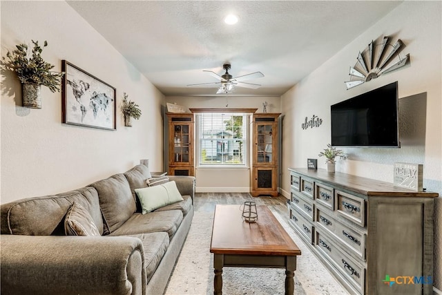 living room featuring wood-type flooring and ceiling fan