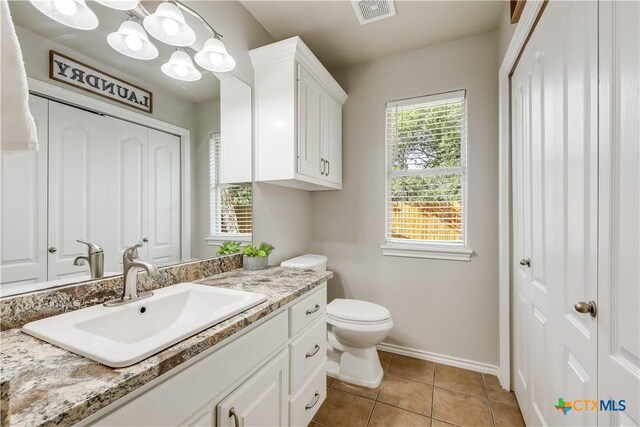 bathroom featuring tile patterned flooring, vanity, and toilet