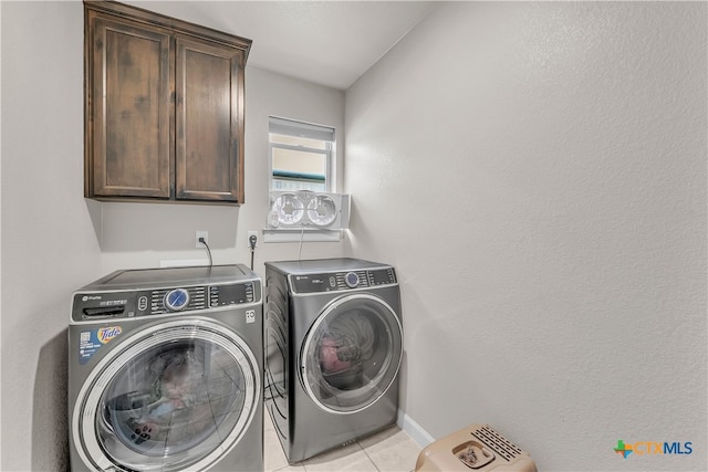 laundry area featuring cabinets, light tile patterned flooring, and separate washer and dryer