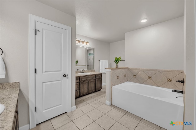 bathroom featuring tile patterned flooring, vanity, and a tub to relax in