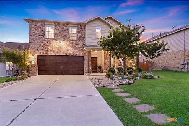 272 Adoquin Trl, Buda, TX 78610 - view of front of property featuring a garage, concrete driveway, a lawn, and brick siding