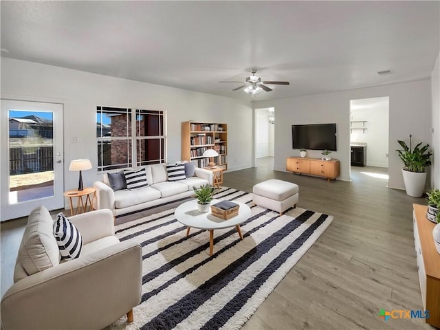 living area featuring ceiling fan, visible vents, and wood finished floors