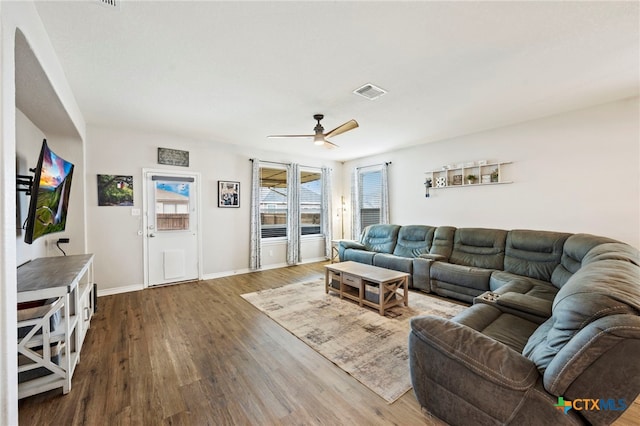 living room featuring visible vents, baseboards, wood finished floors, and ceiling fan
