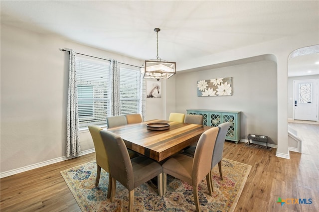 dining room with baseboards, wood finished floors, and a chandelier