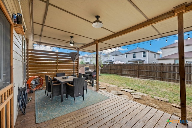deck with a lawn, a fenced backyard, outdoor dining area, and a residential view