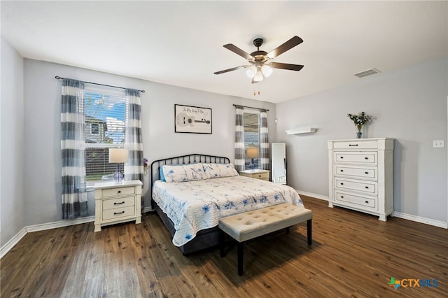 bedroom featuring baseboards, a ceiling fan, visible vents, and dark wood-style flooring