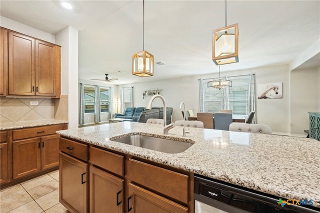 kitchen with dishwasher, brown cabinets, a wealth of natural light, and tasteful backsplash